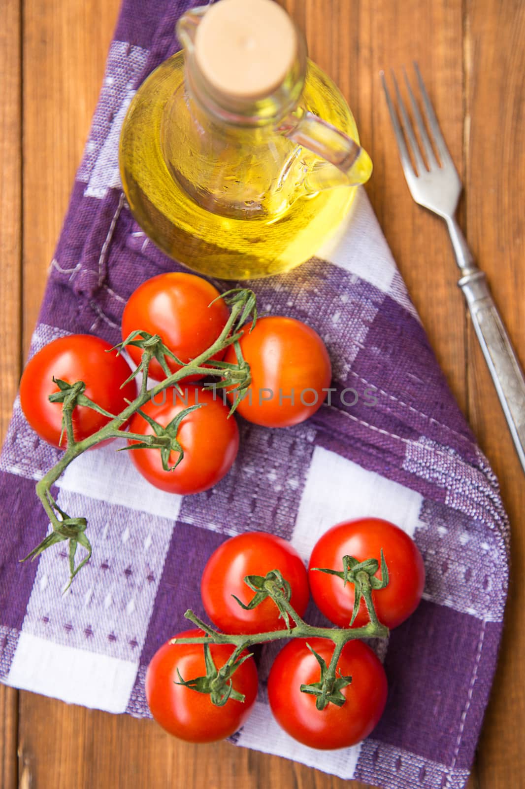 few fresh ripe tomatoes on a branch with olive oil