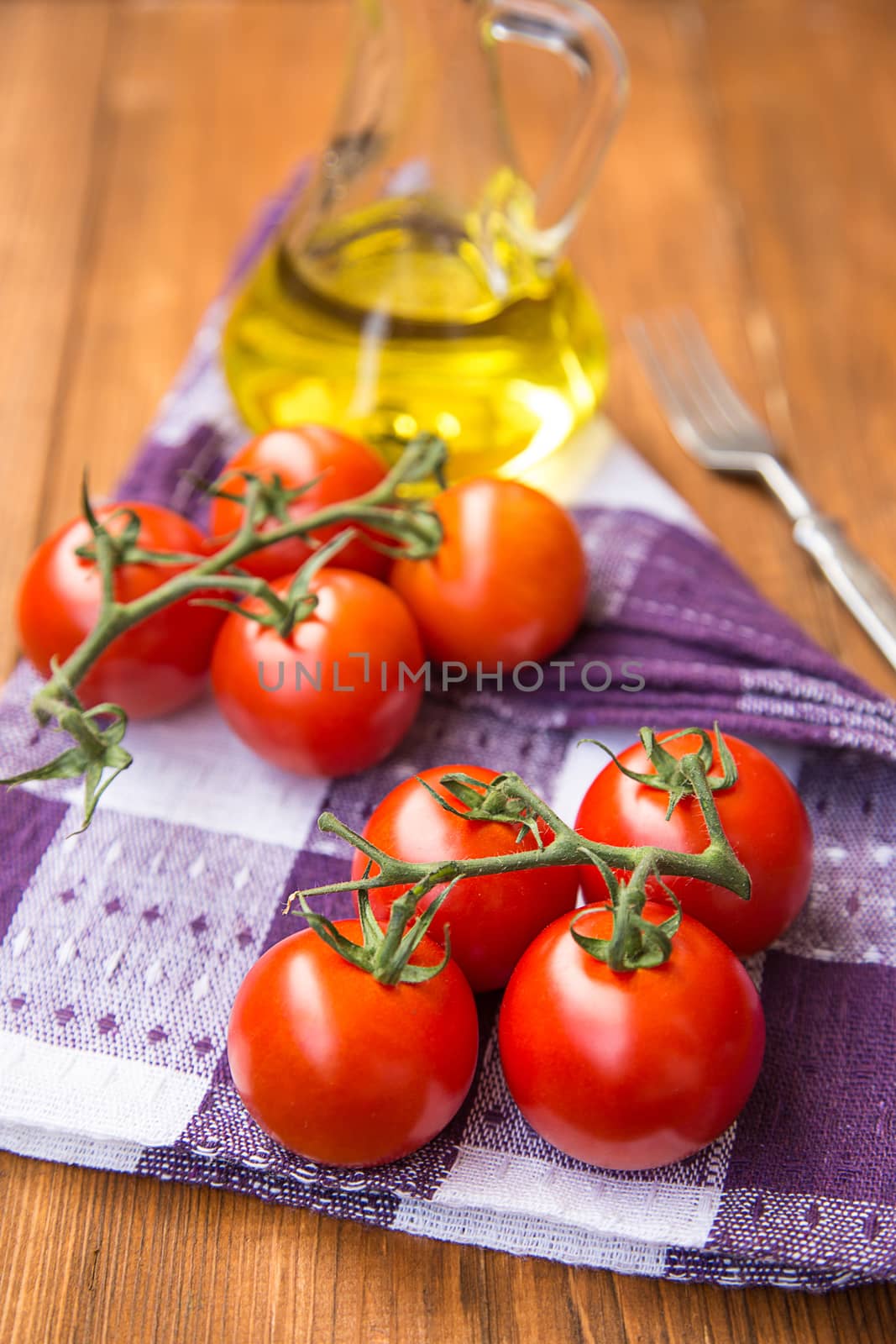 few fresh ripe tomatoes on a branch with olive oil