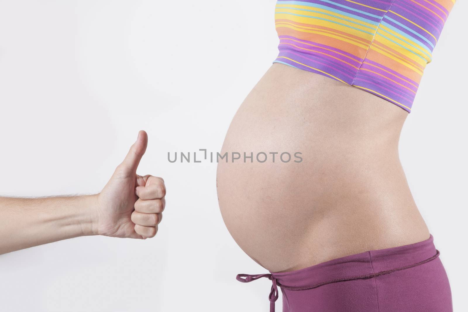 hand okay to tummy of naked pregnant woman