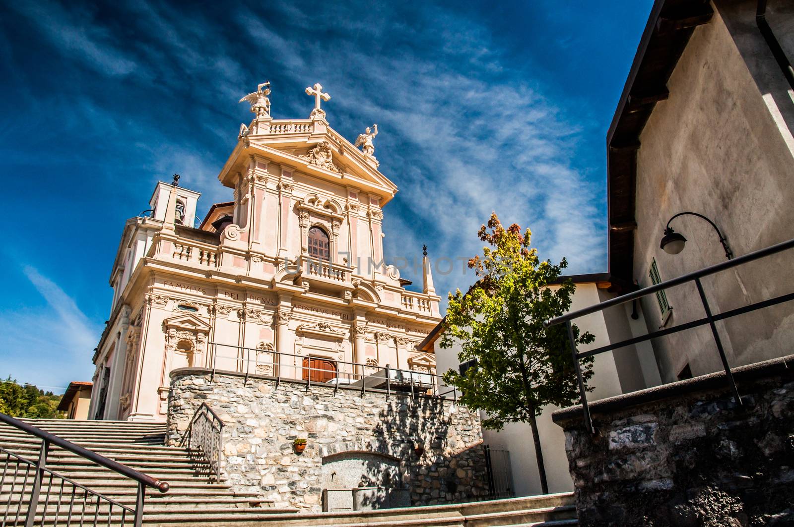 Steps leading to the entrance of an old church with blue sky and clouds behind.