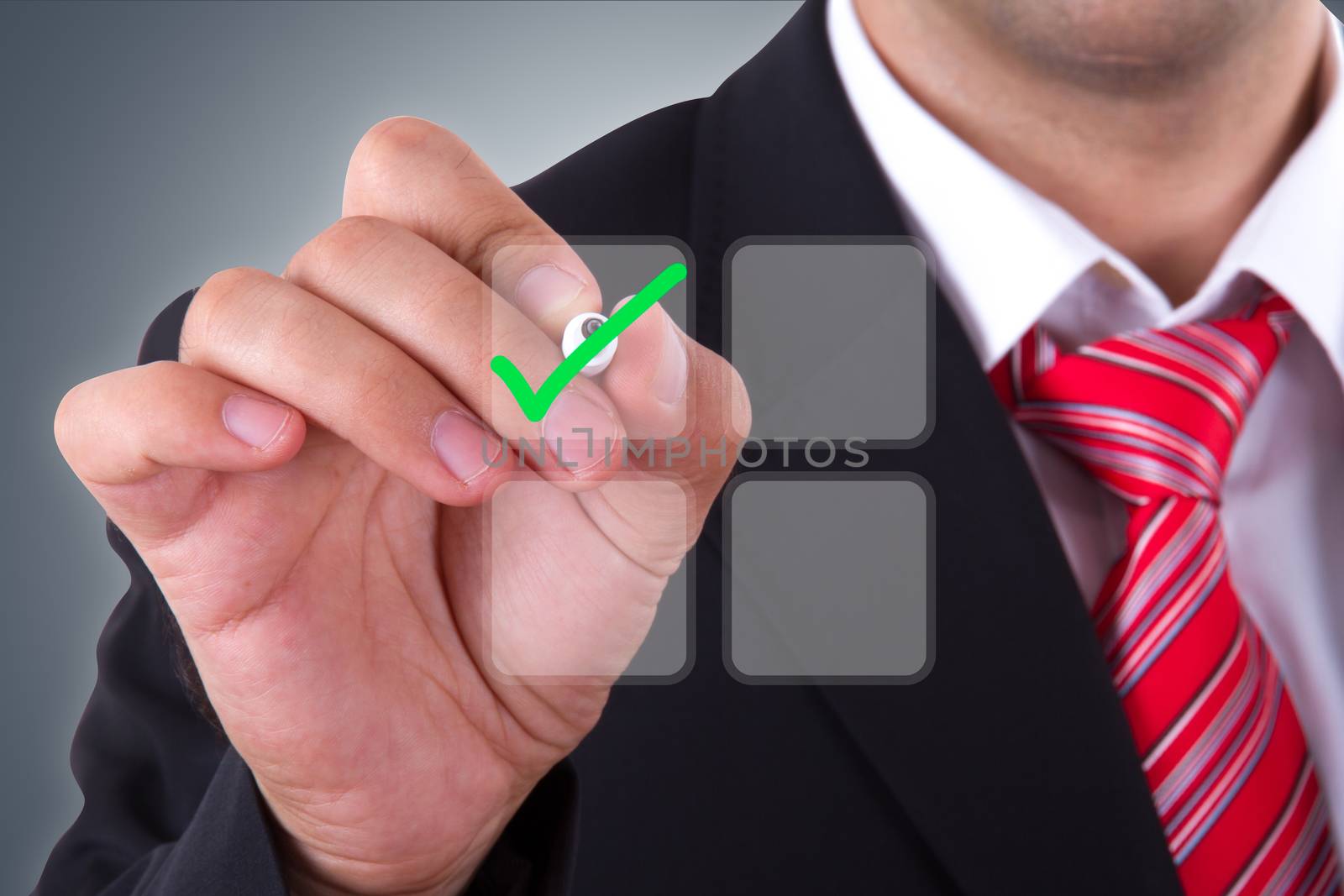 Businessman holding pen and checking check mark of list on digital screen.