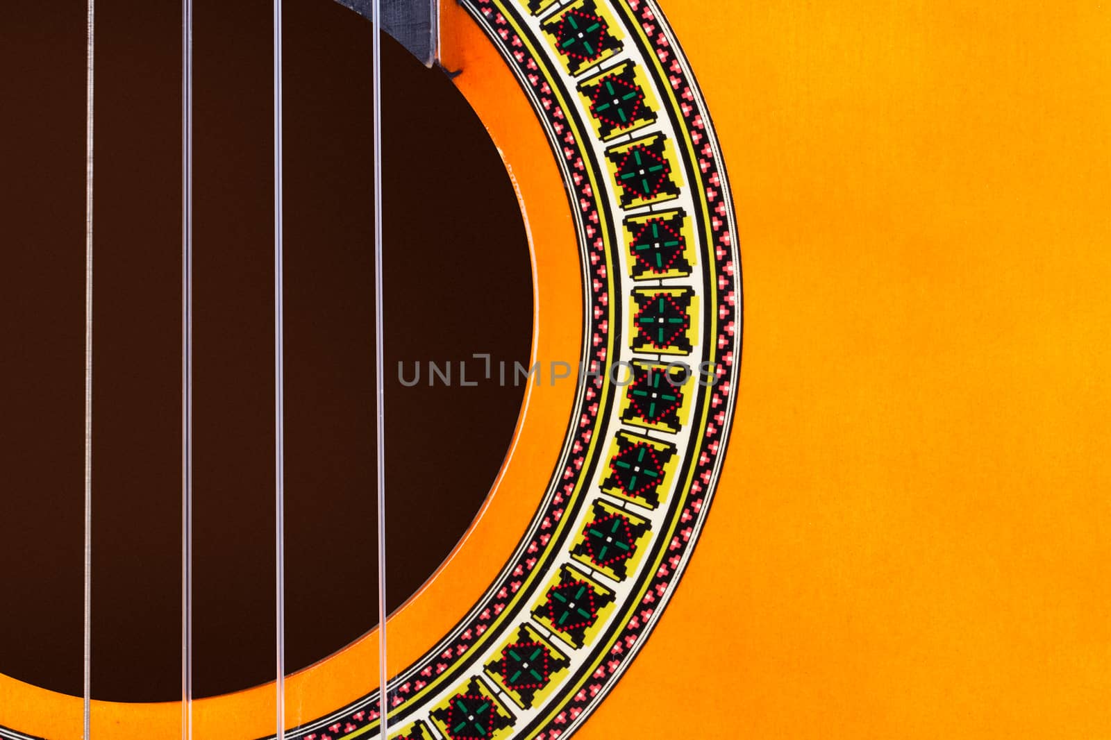 Detail view of yellow wooden classical acoustic guitar.