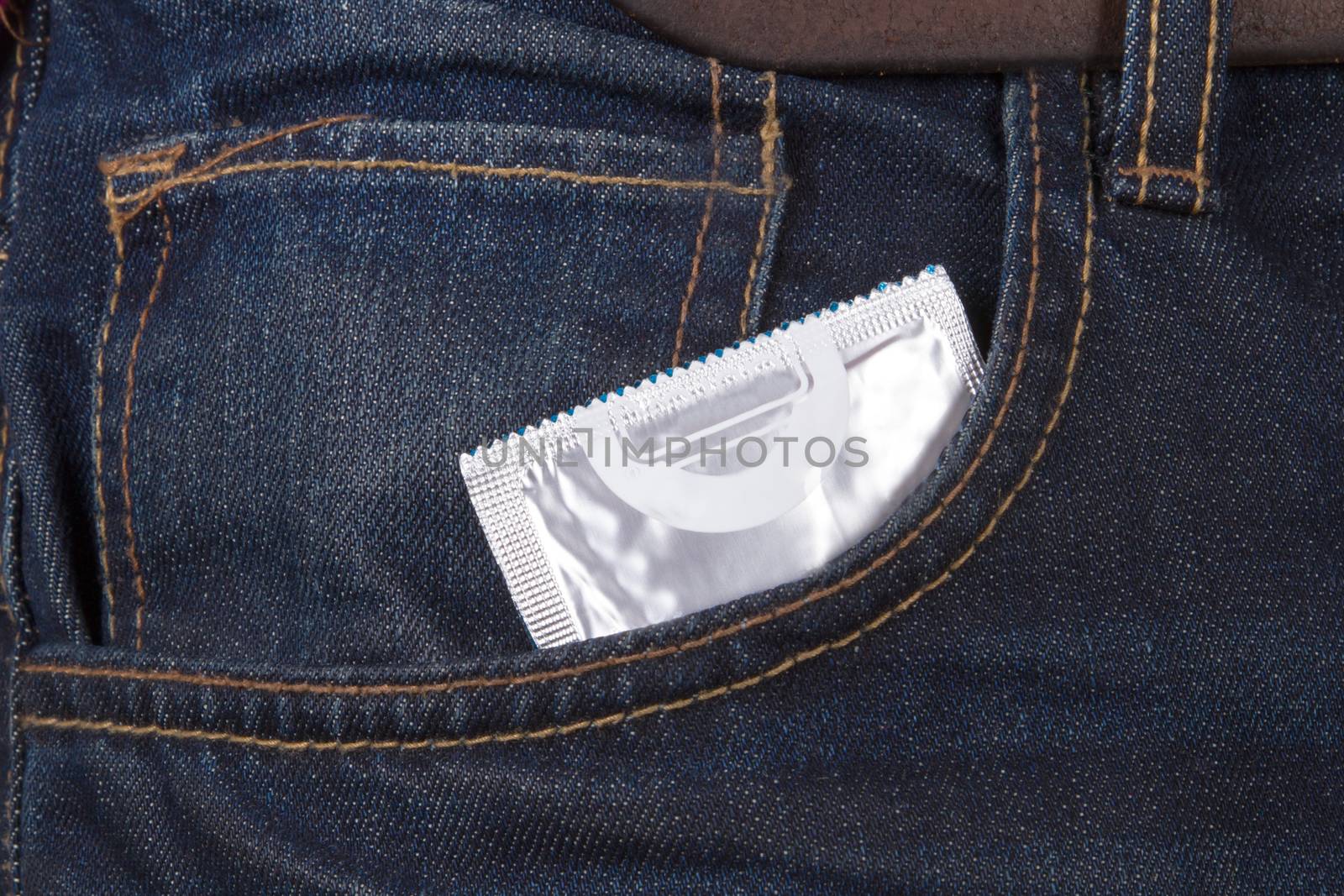 Condom packet in jeans pocket for safe sex.
