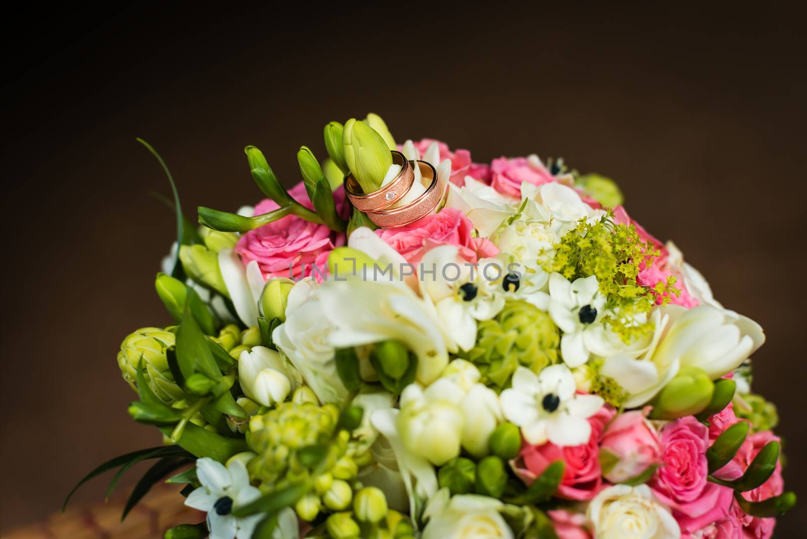 Two golden wedding rings on bridal bouquet 