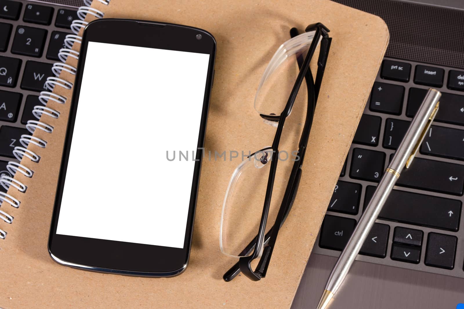 new mobile phone with glasses on notebook