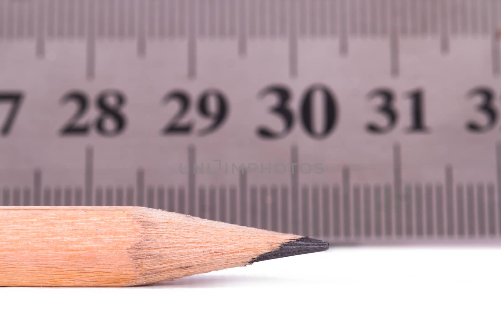Close up view of wood pencil and steel ruler for engineering drawing, isolated on white background.