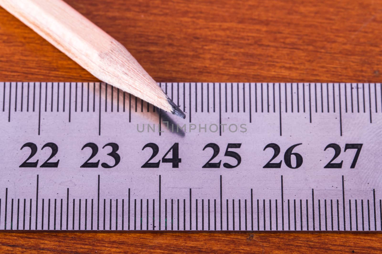 Close up view of wood pencil and steel ruler for engineering drawing on wooden table.