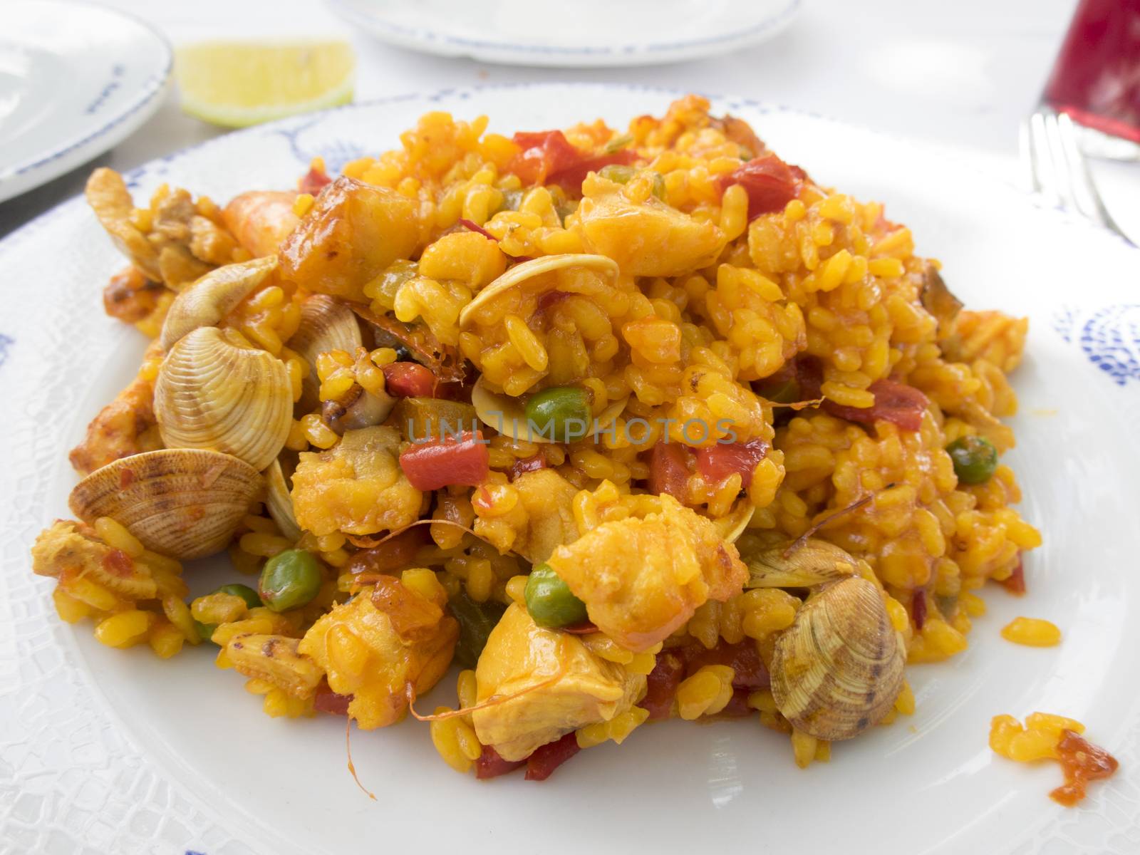 plate of spanish paella with clams and chicken on white dish