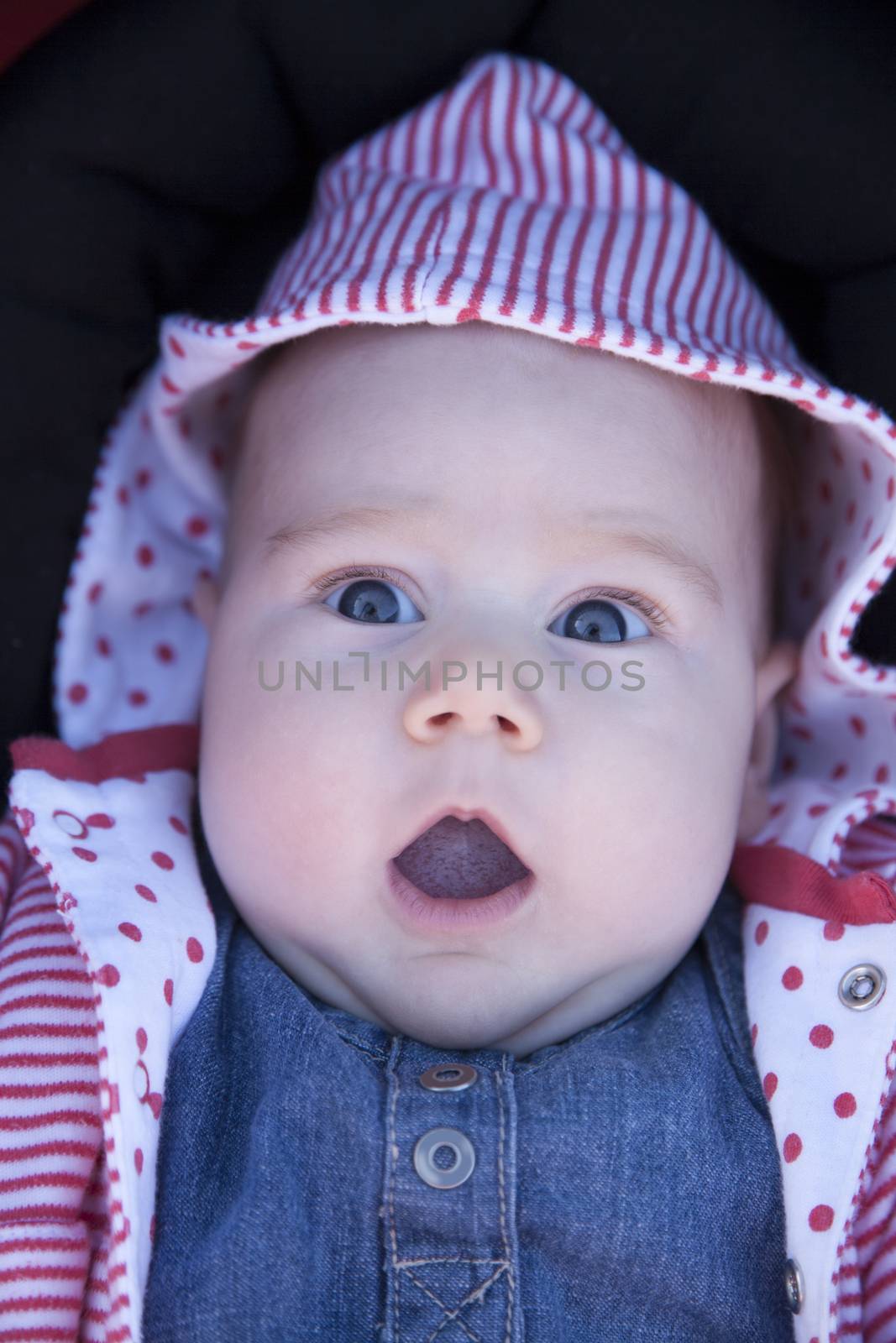 three month baby with jeans dress looking at camera with horror fright face