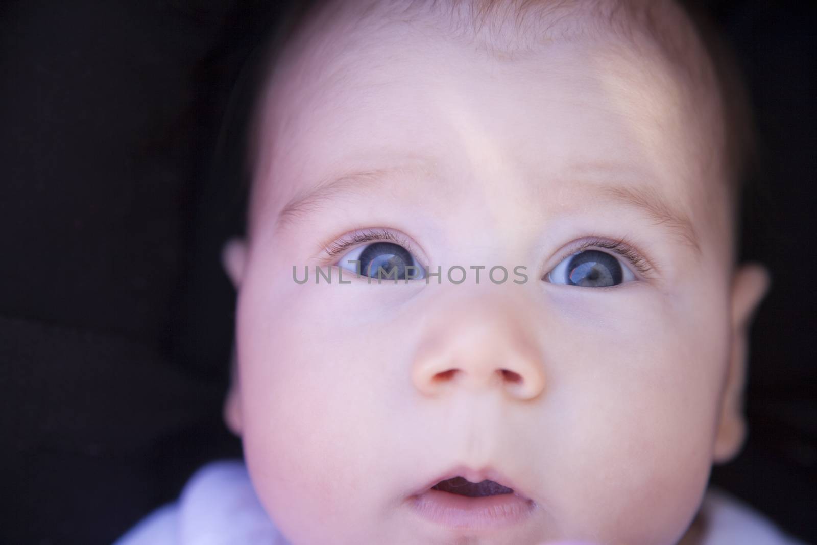 three month baby with jeans dress looking at camera with terror fright face
