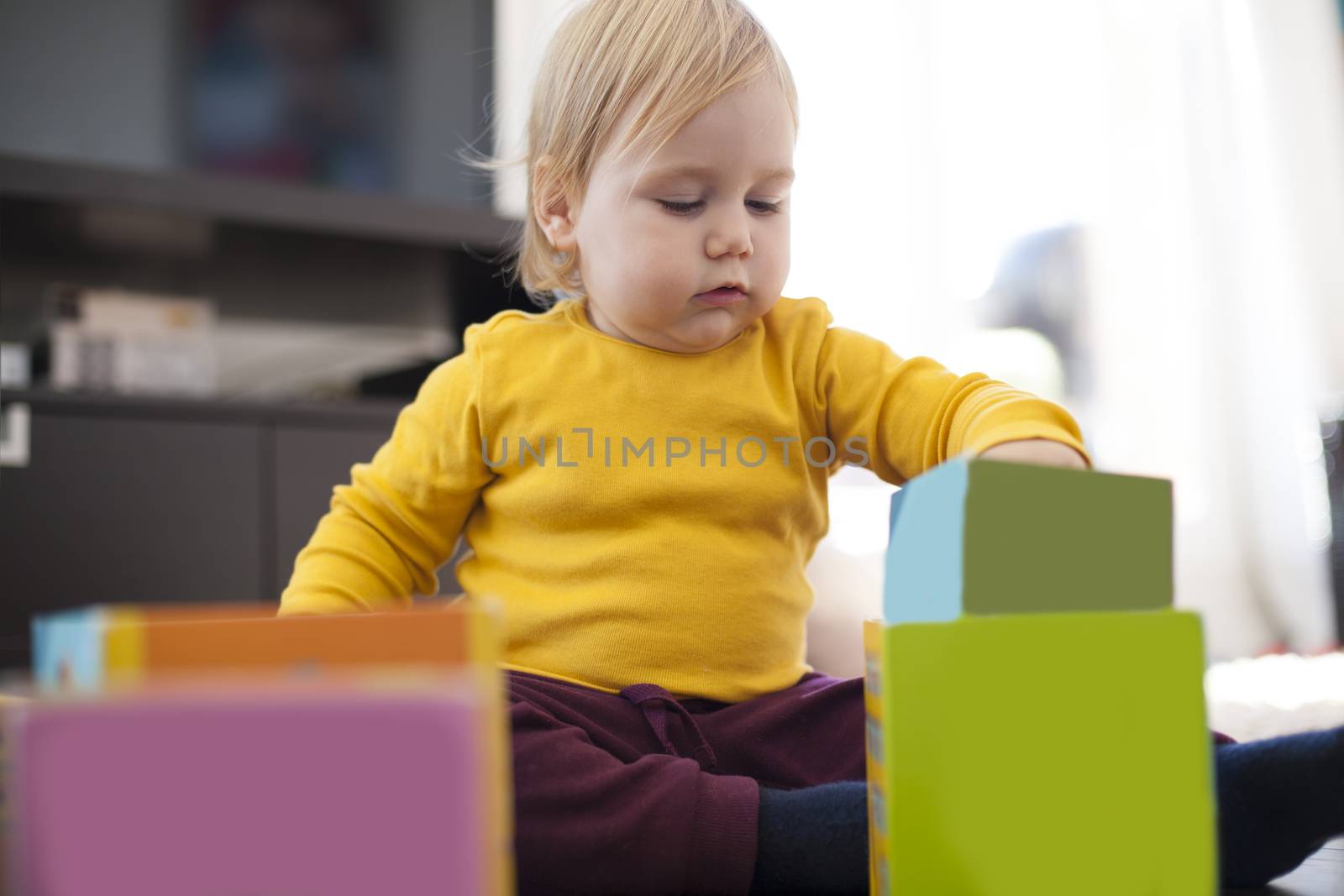 yellow sweater baby placing boxes by quintanilla