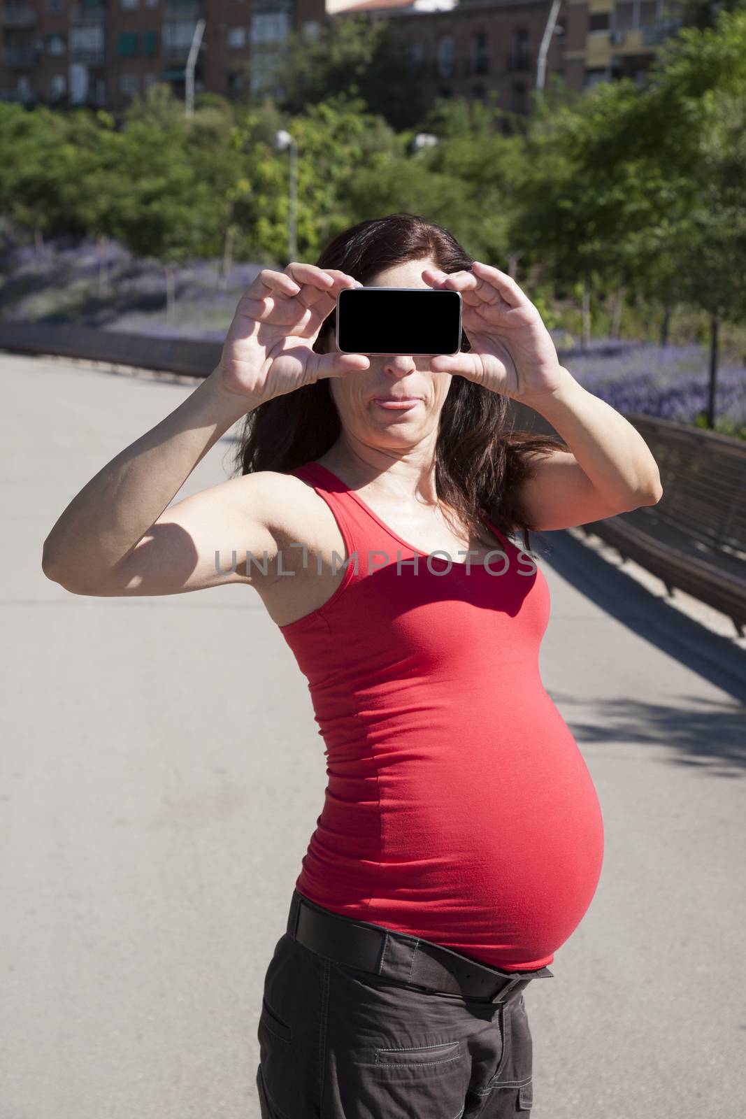 funny pregnant woman with smartphone in her hands