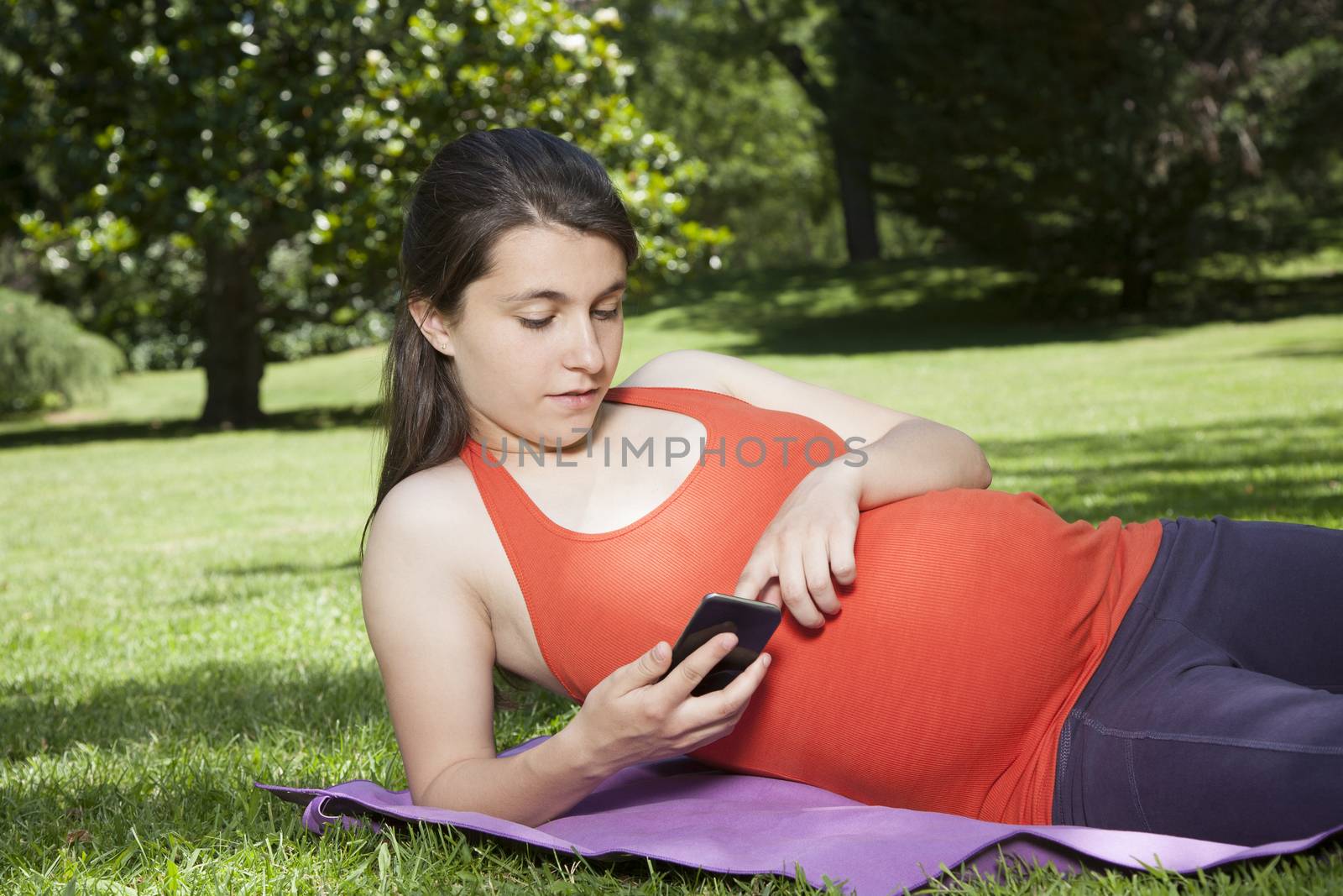 lying pregnant with smartphone by quintanilla