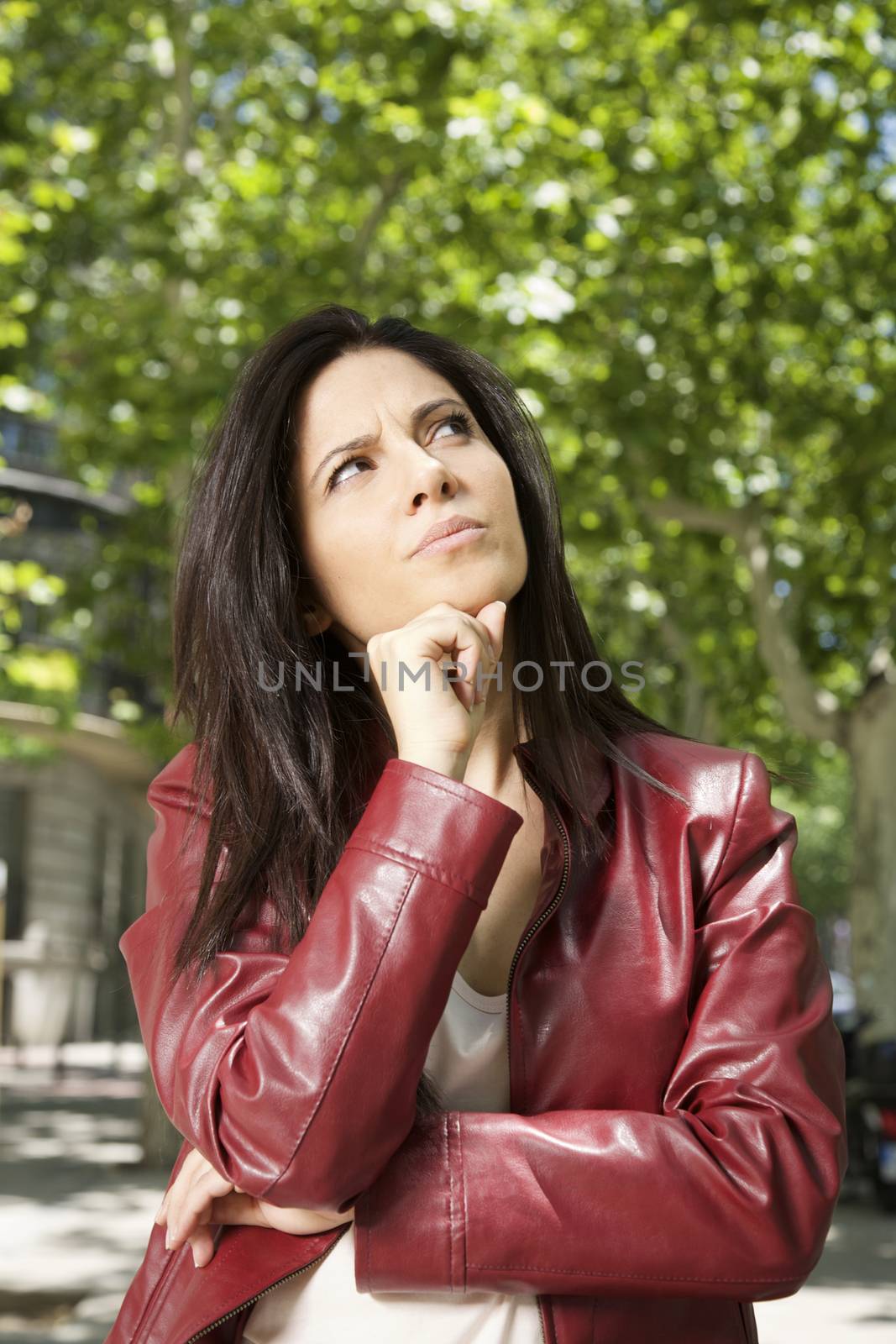 pretty brunette woman with red leather jacket thinking
