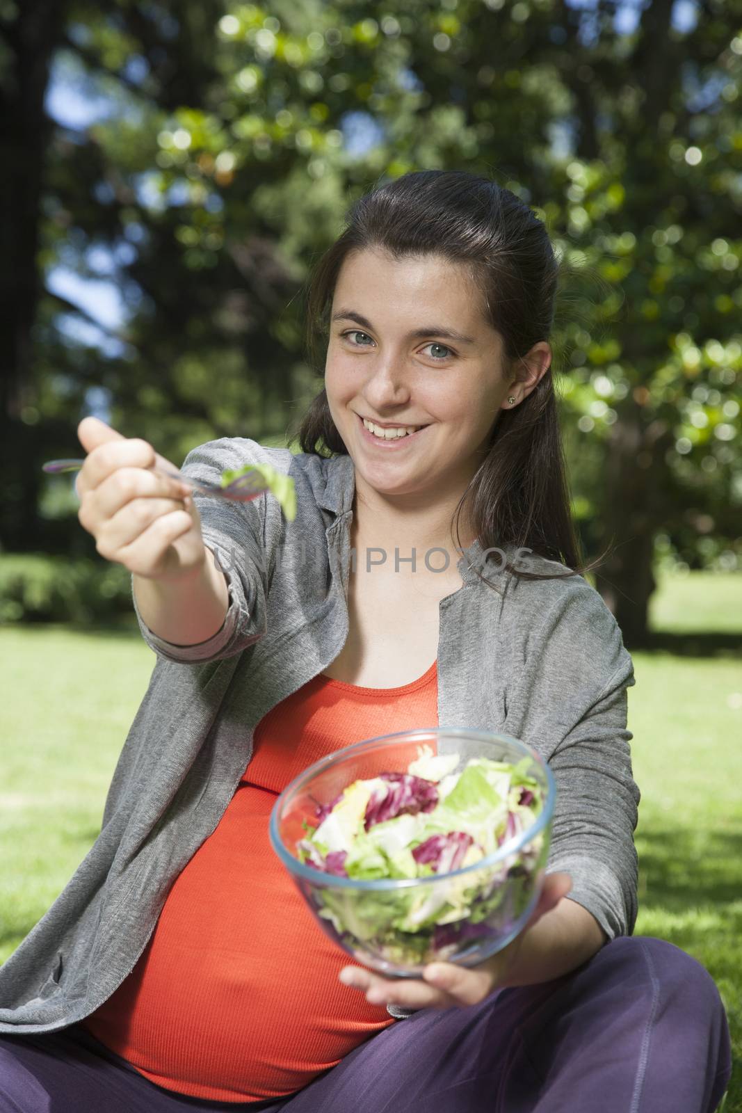 young pregnant offering salad by quintanilla