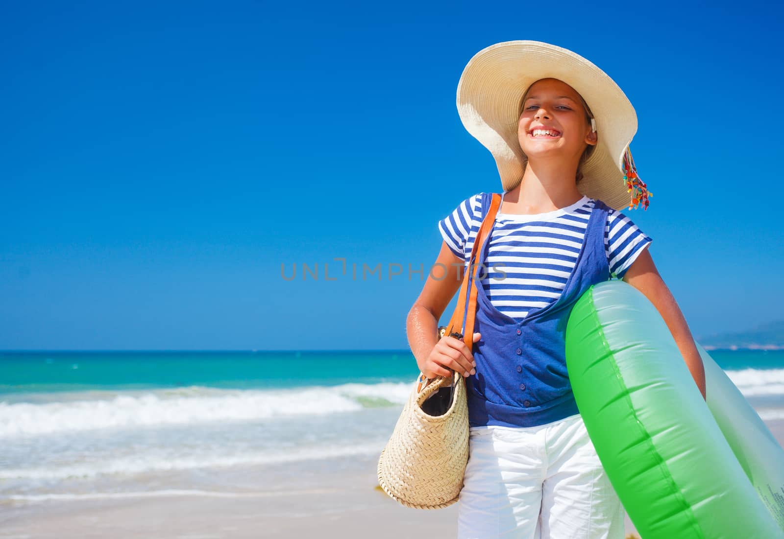 Summer vacation, lovely girl walking on the beach near water