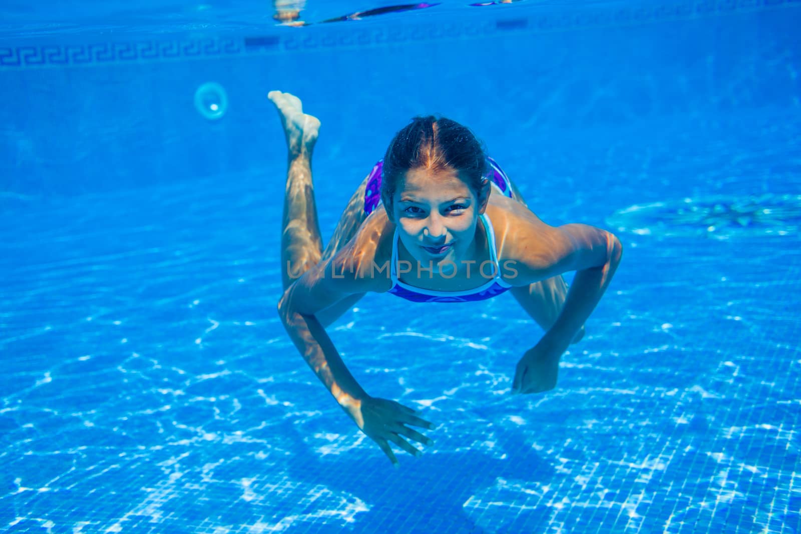 Underwater happy cute girl in swimming pool