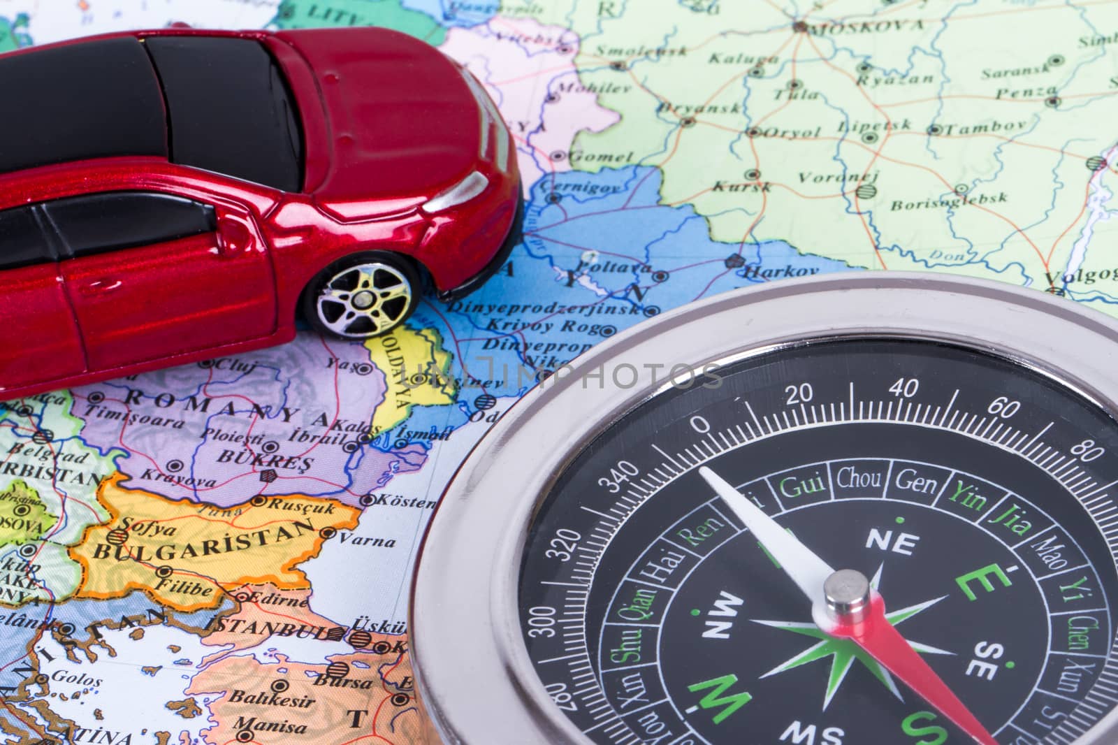 Travel concept, compass and small, toy car map, isolated on white background.