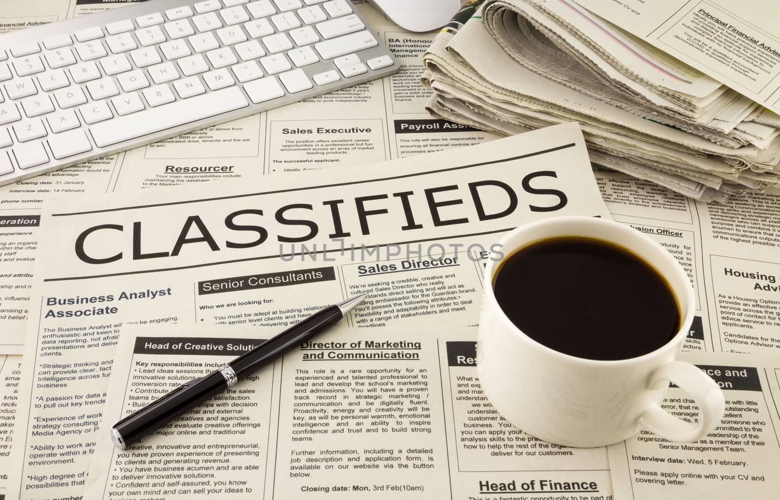 fake newspaper display classifieds advertising place on table with keyboard, pen and a cup of coffee