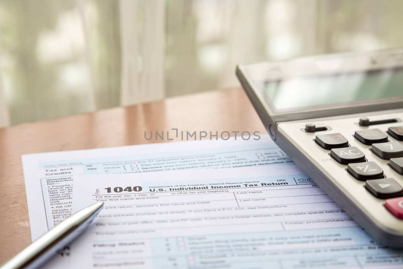 Form 1040, U.S. Individual income tax return place on table with calculator and pen