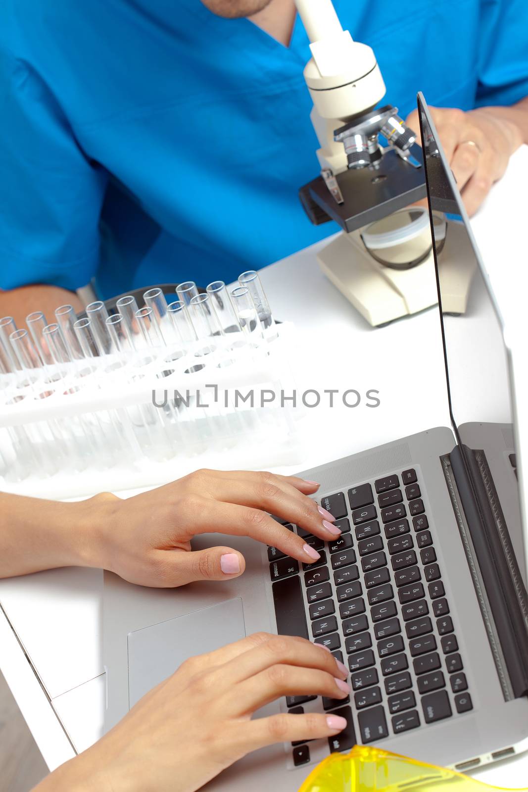 Scientist hands on laptop keyboard