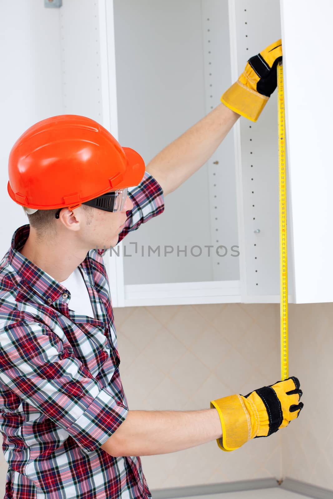 young builder with yellow tape measure