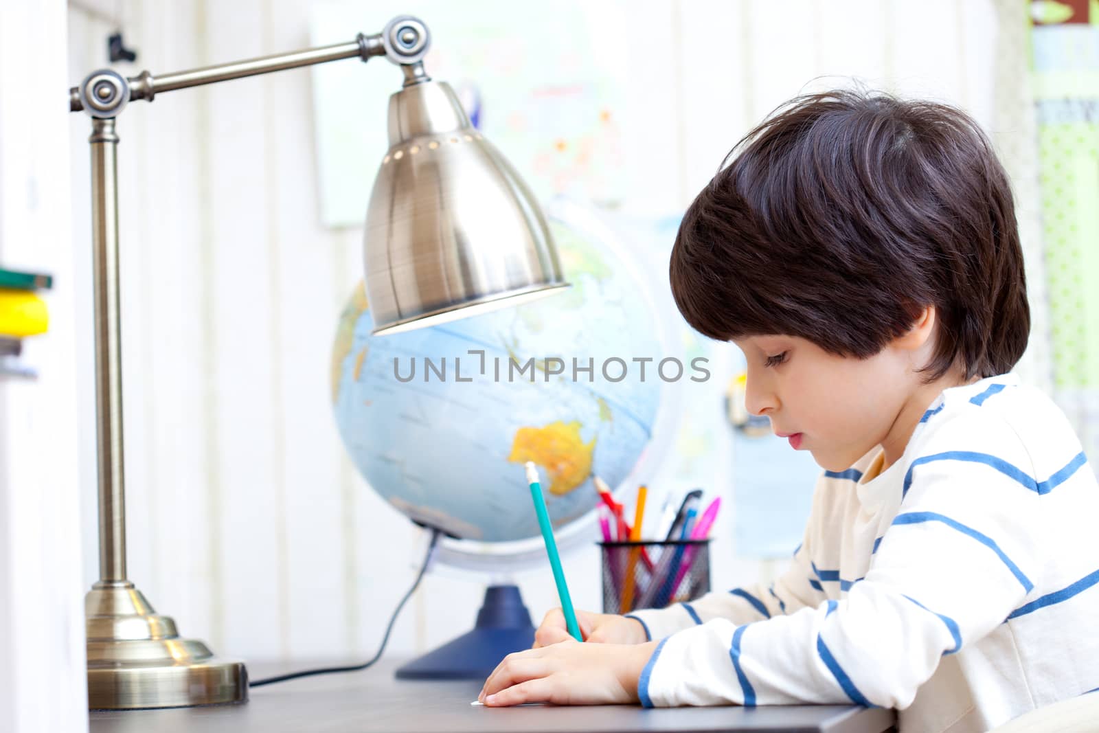 schoolboy doing homework at his desk