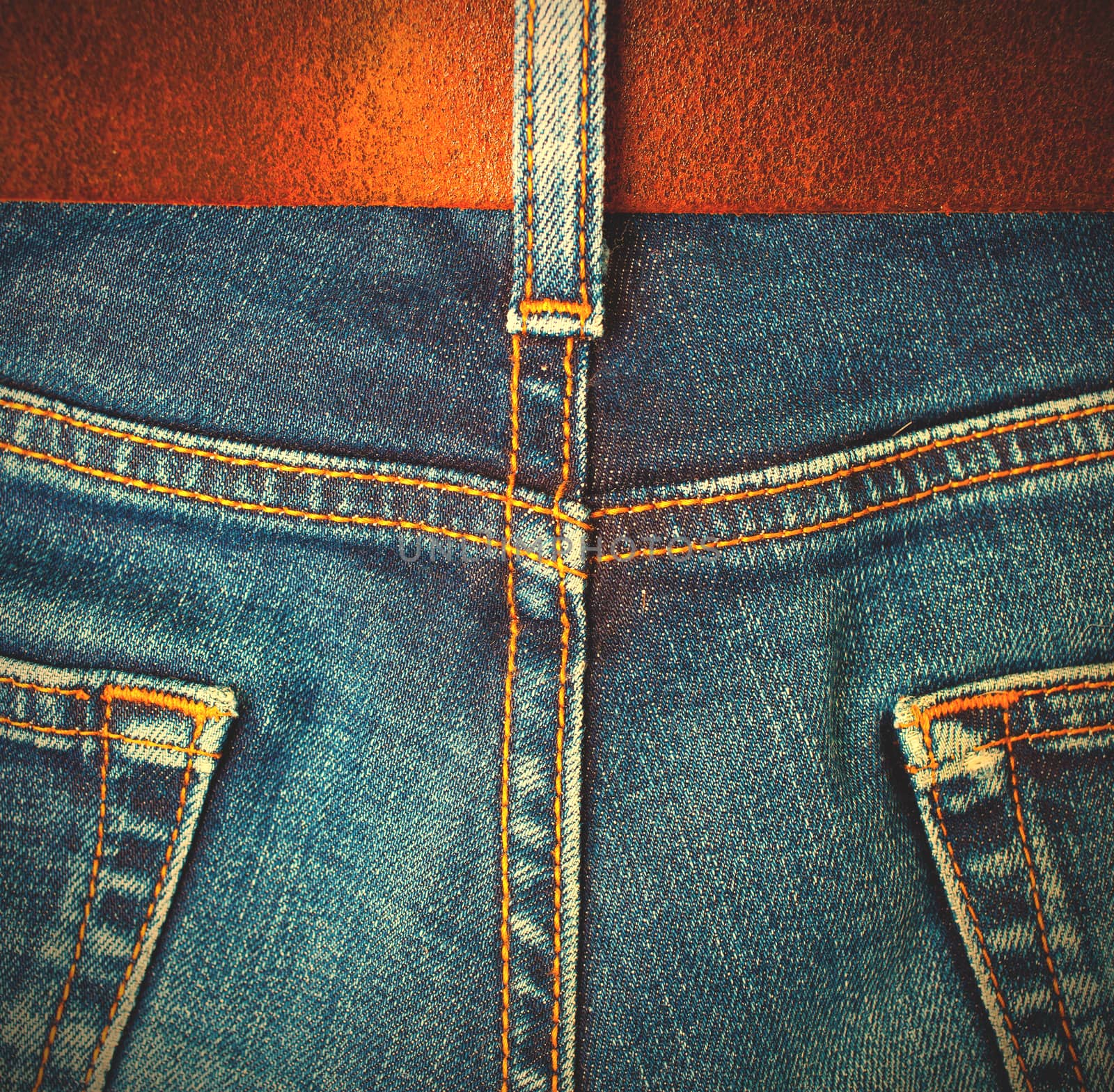 Aged blue jeans with leather belt, back view. Instagram image style