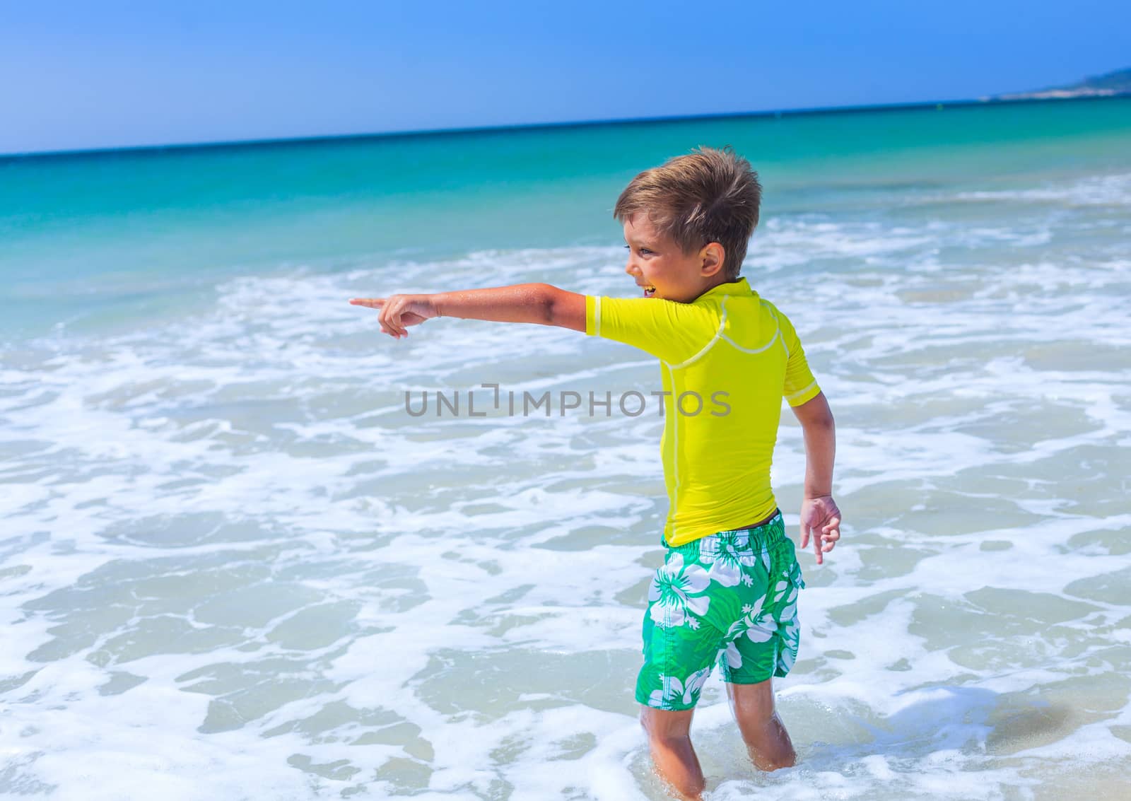 Little cute boy relaxing at the beach near ocean