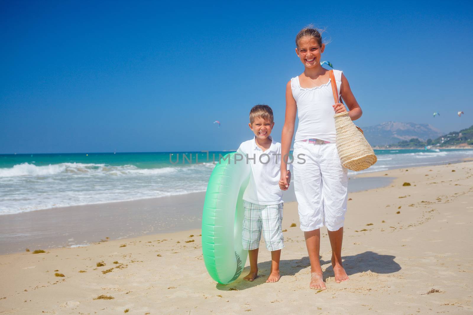 Beautiful brother and sister walk on the beach