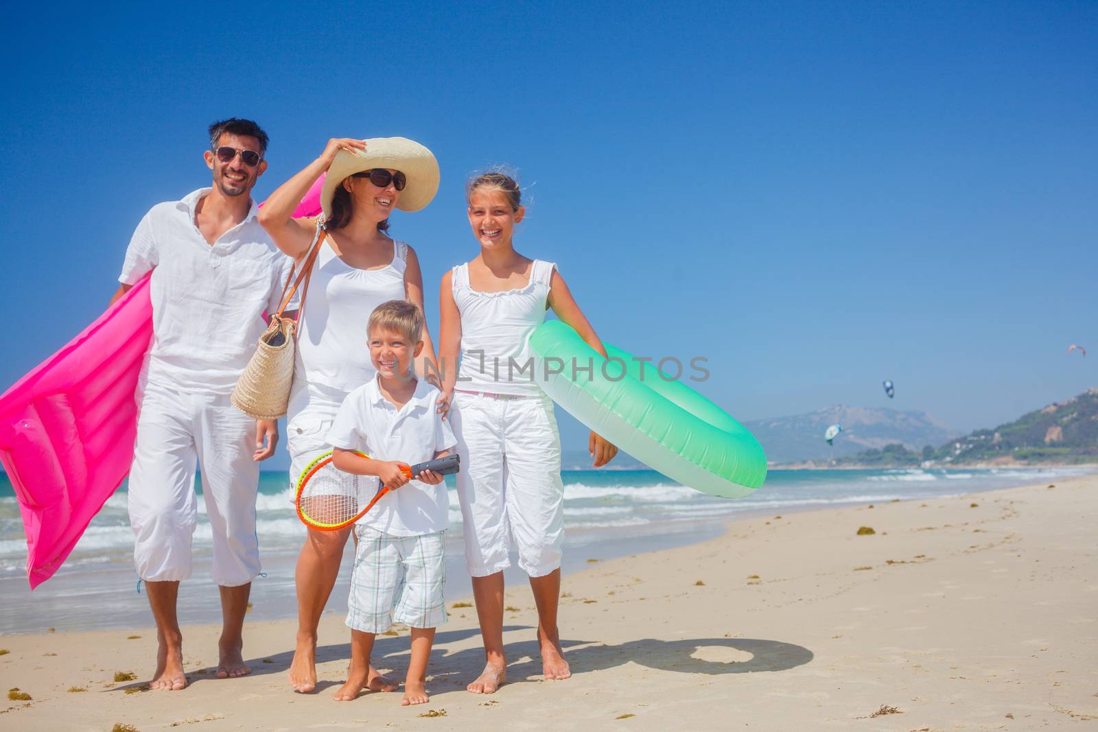 Family of four having fun on tropical beach