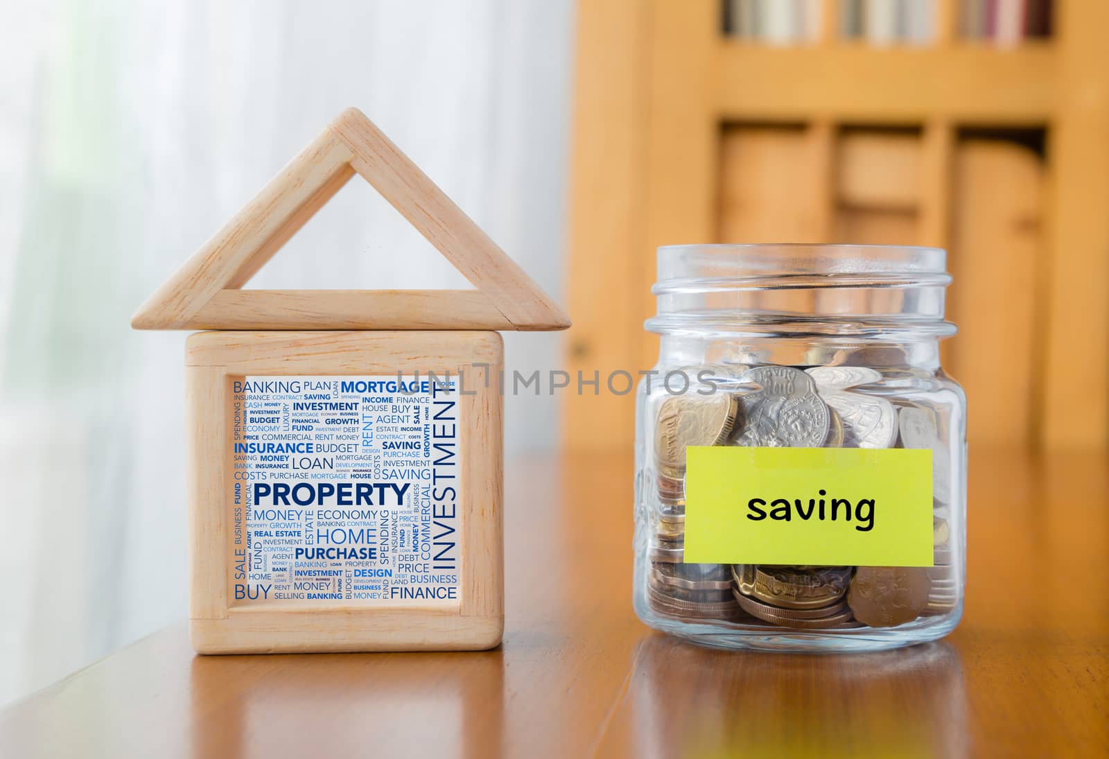 Saving label on money jar and wooden home  blocks with investment property word cloud