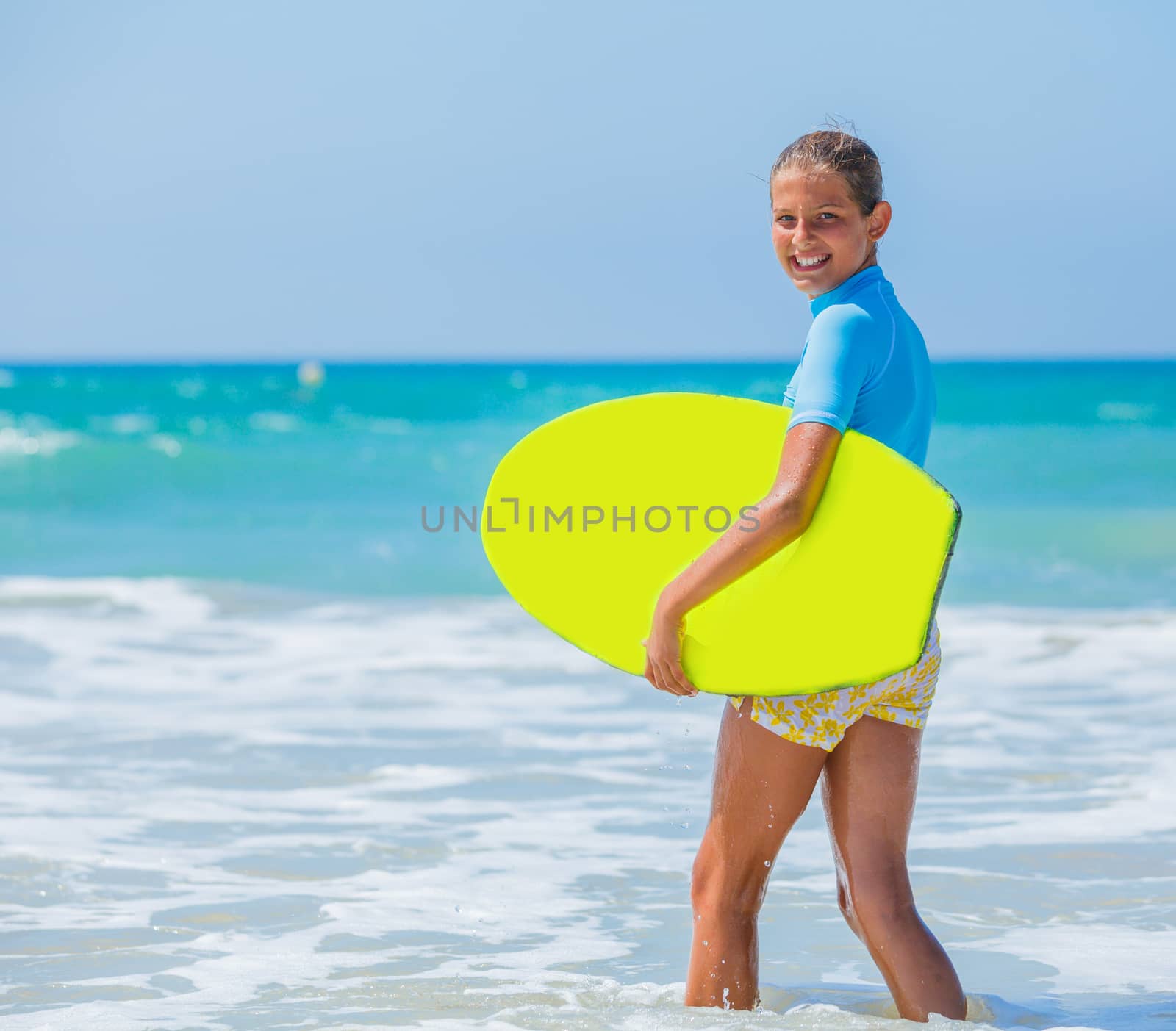 Teenage girl in blue has fun surfing