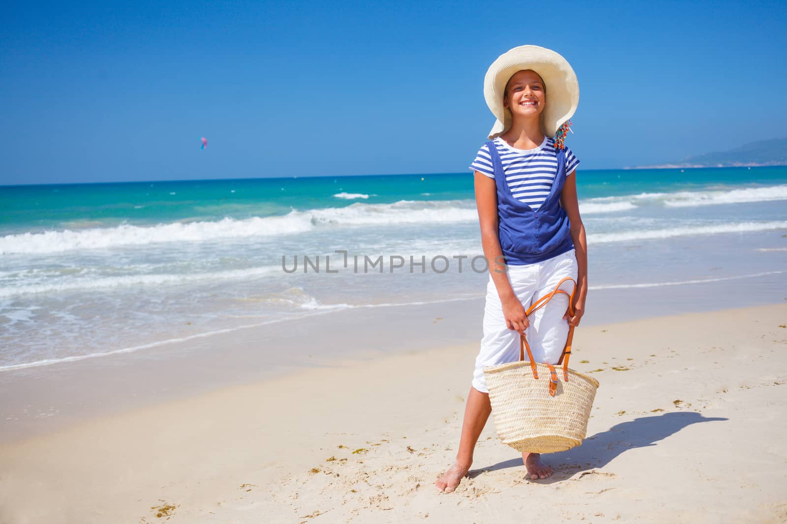 Summer vacation, lovely girl walking on the beach near water