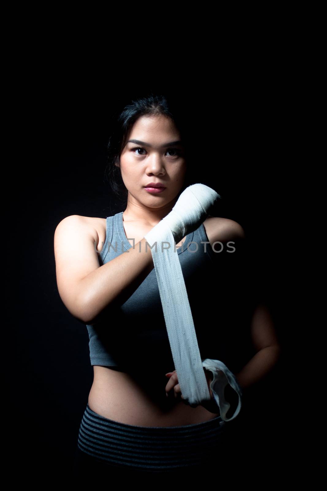 Asian female boxer on black background