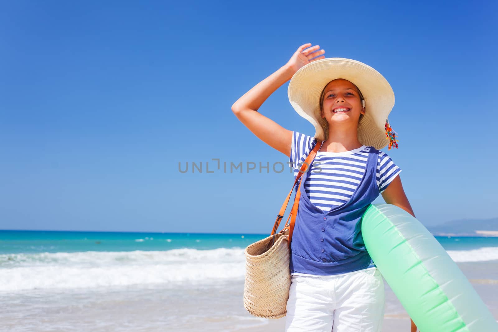 Summer vacation, lovely girl walking on the beach near water