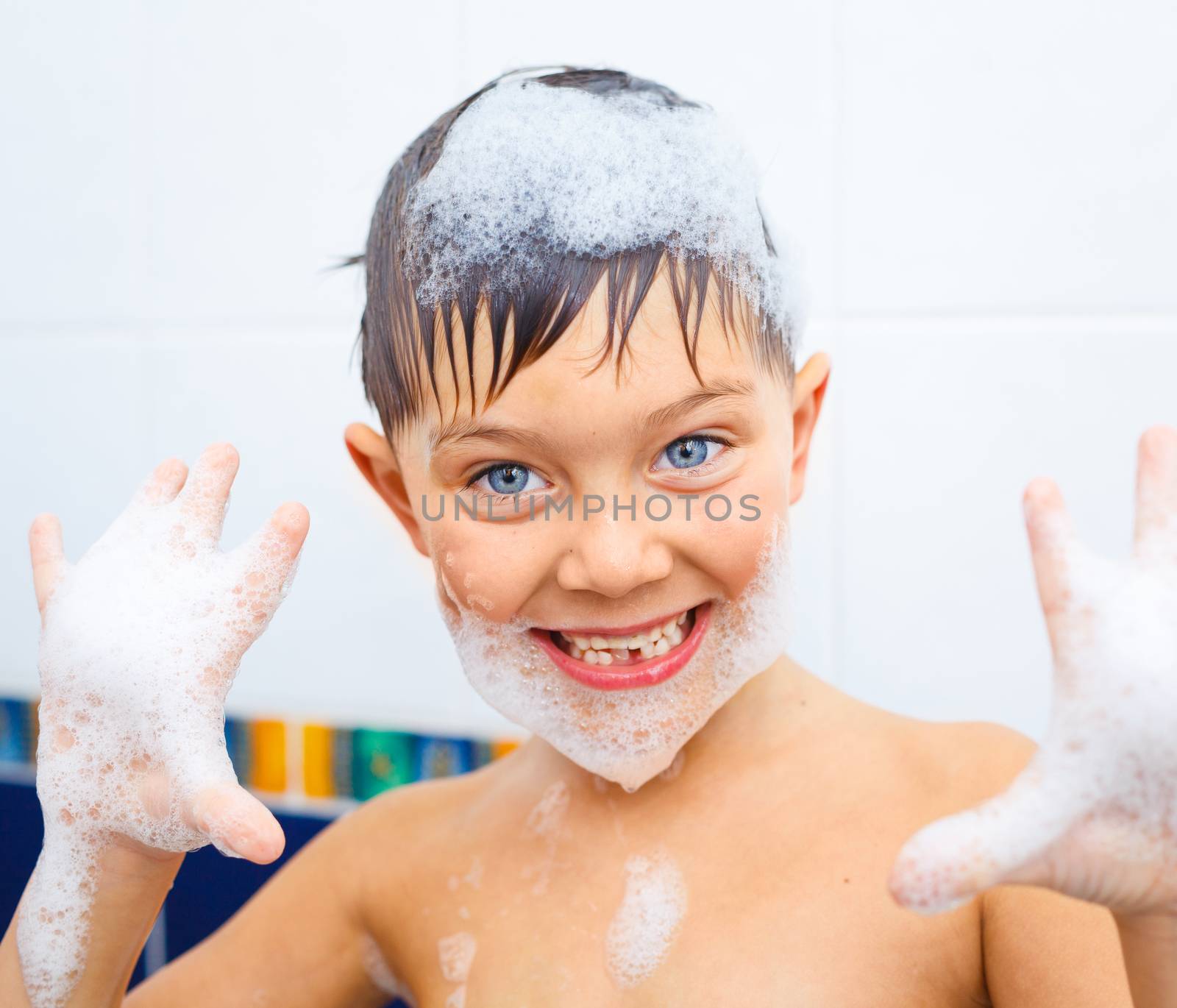 Portrait of cute little boy in bathroom with foam