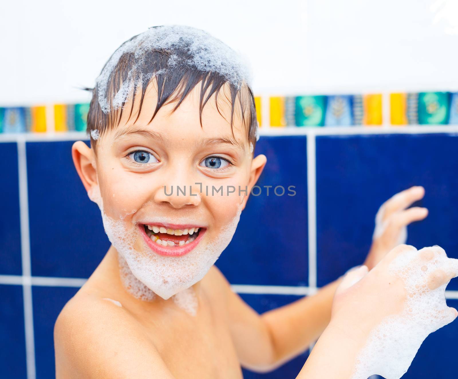 Portrait of cute little boy in bathroom with foam