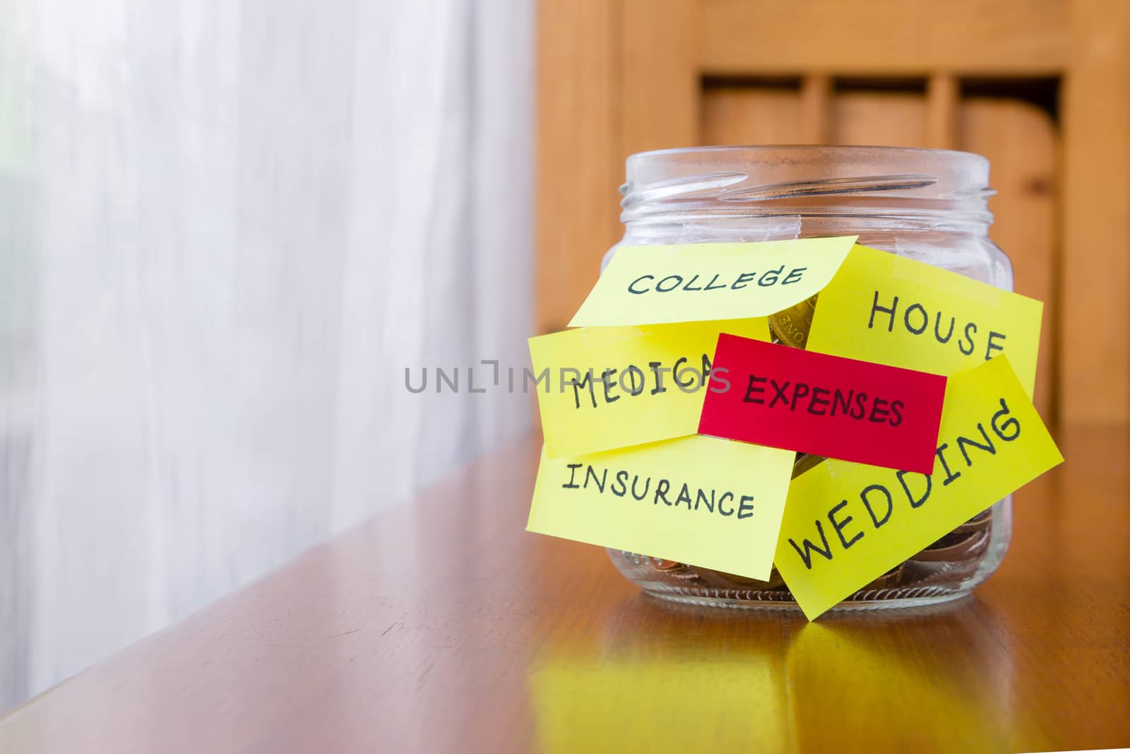 Expenses and orther tags on savings money jar by vinnstock