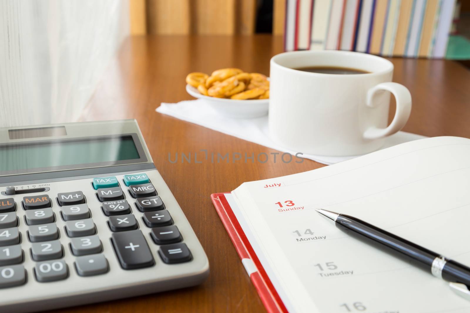 Blank timetable or calendar place on table with calculator and coffee break