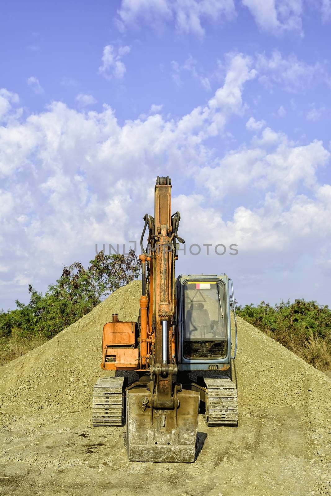 Parked earth mover on top of gravel mound