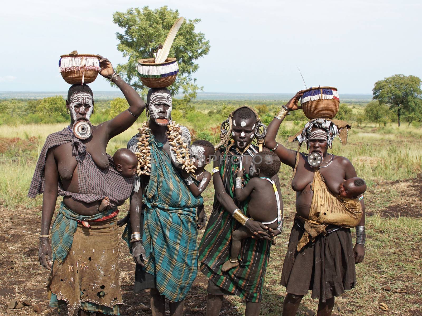 JINKA, ETHIOPIA - NOVEMBER 21, 2014: Mursi women with traditional lip plate and children on November 21, 2014 in Jinka, Ethiopia.