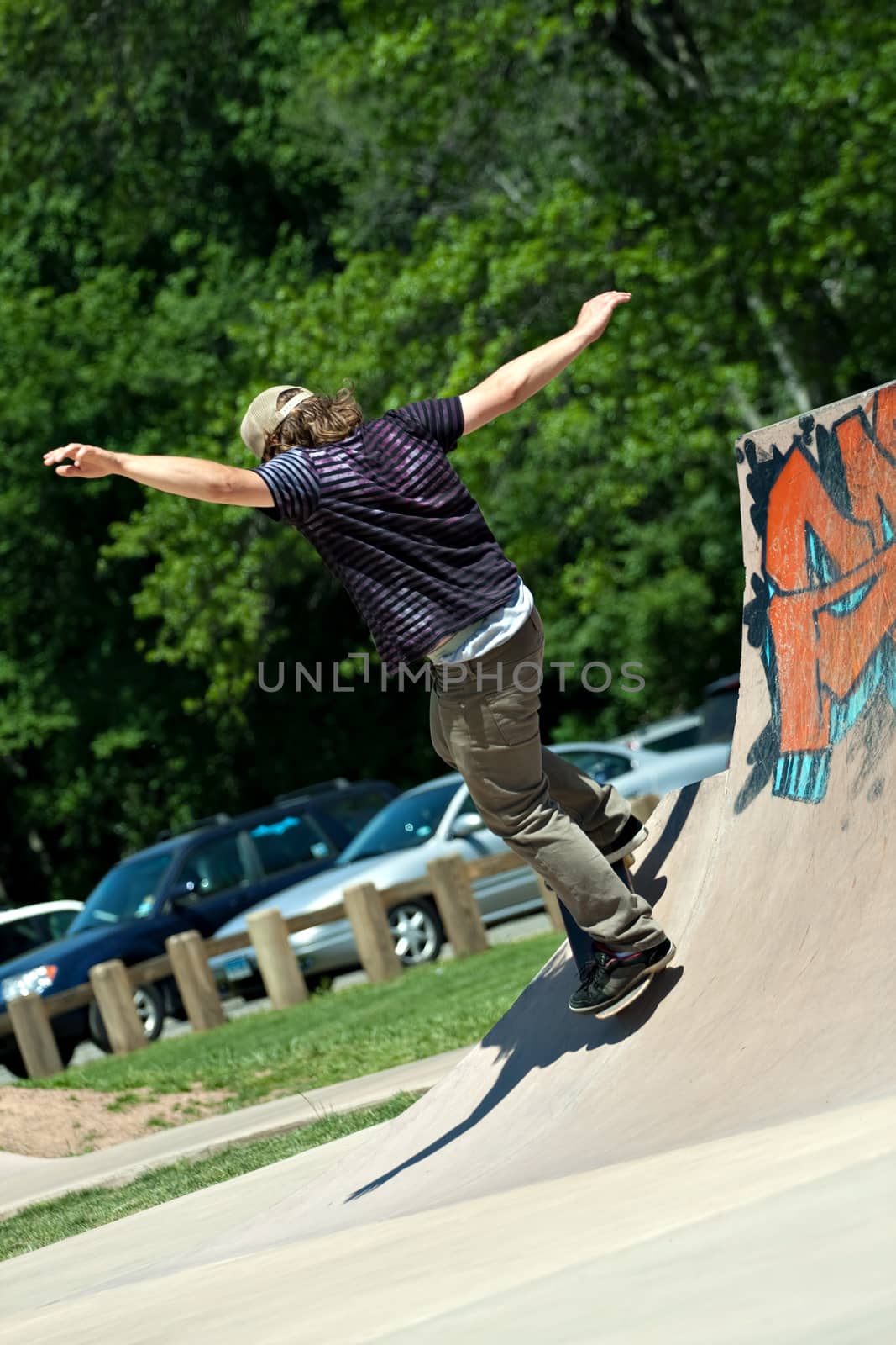 Action shot of a skateboarder skating on a concrete skateboarding ramp at the skate park. Shallow depth of field.