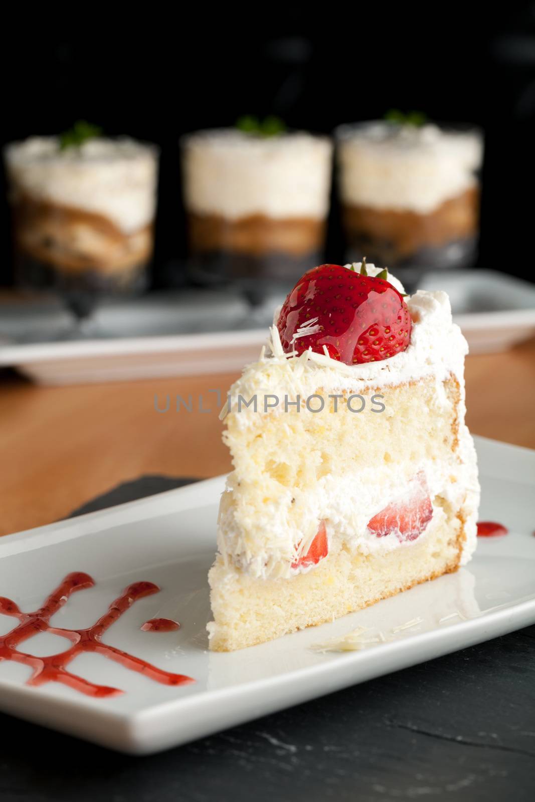 Slice of strawberry shortcake with white chocolate shavings.