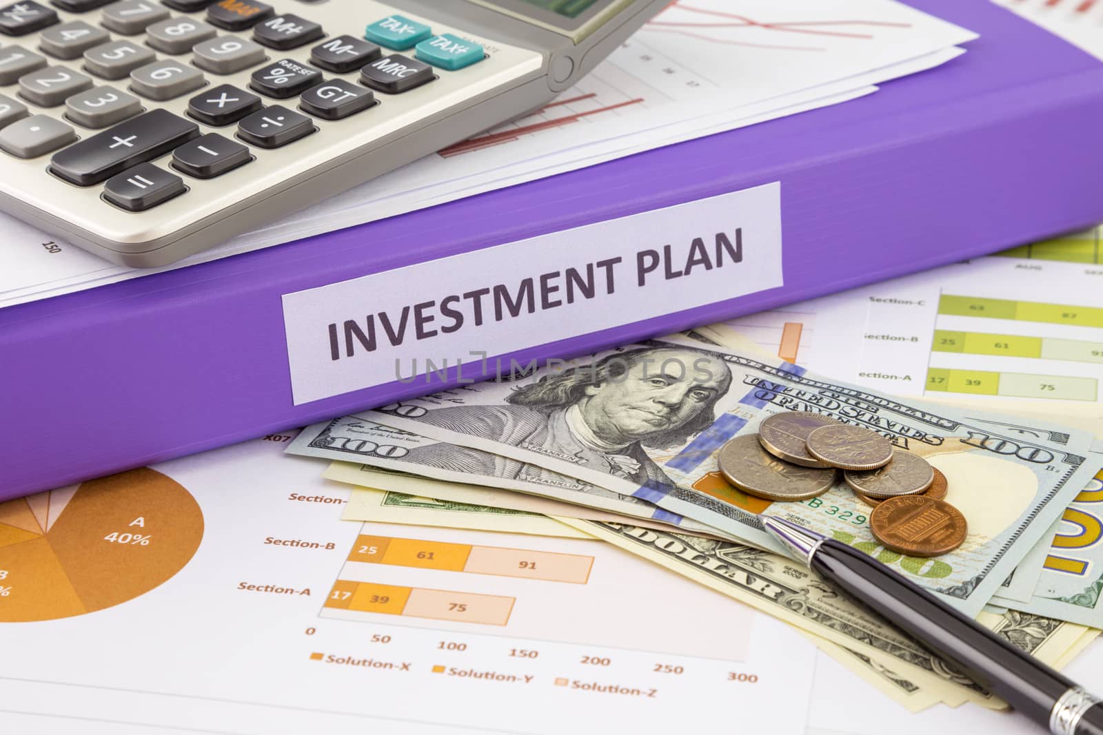 Purple binder of investment plan place on money and financial graphs reports, concept for saving fund and budget management