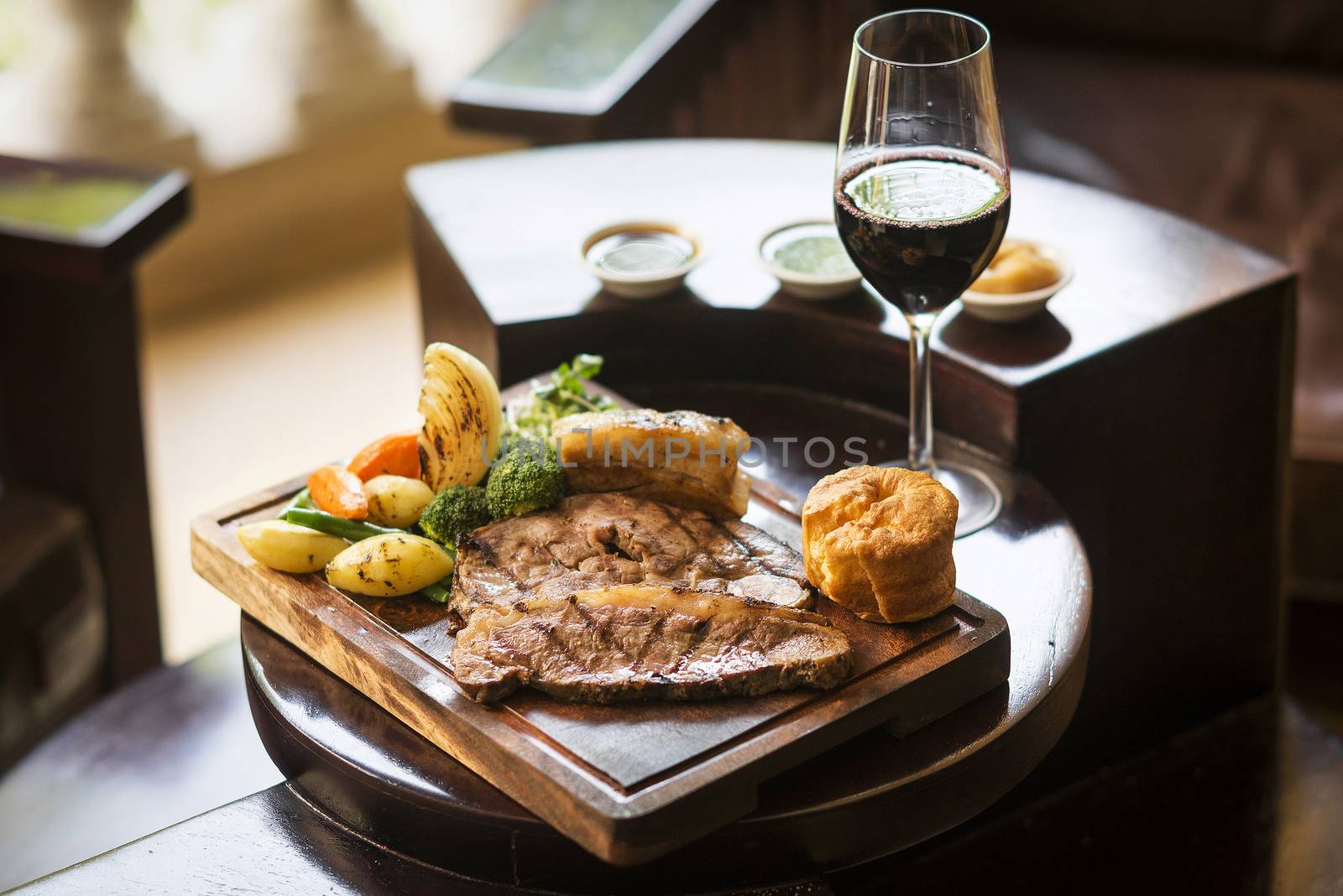 traditional english food sunday roast lunch in cozy restaurant pub with glass of red wine