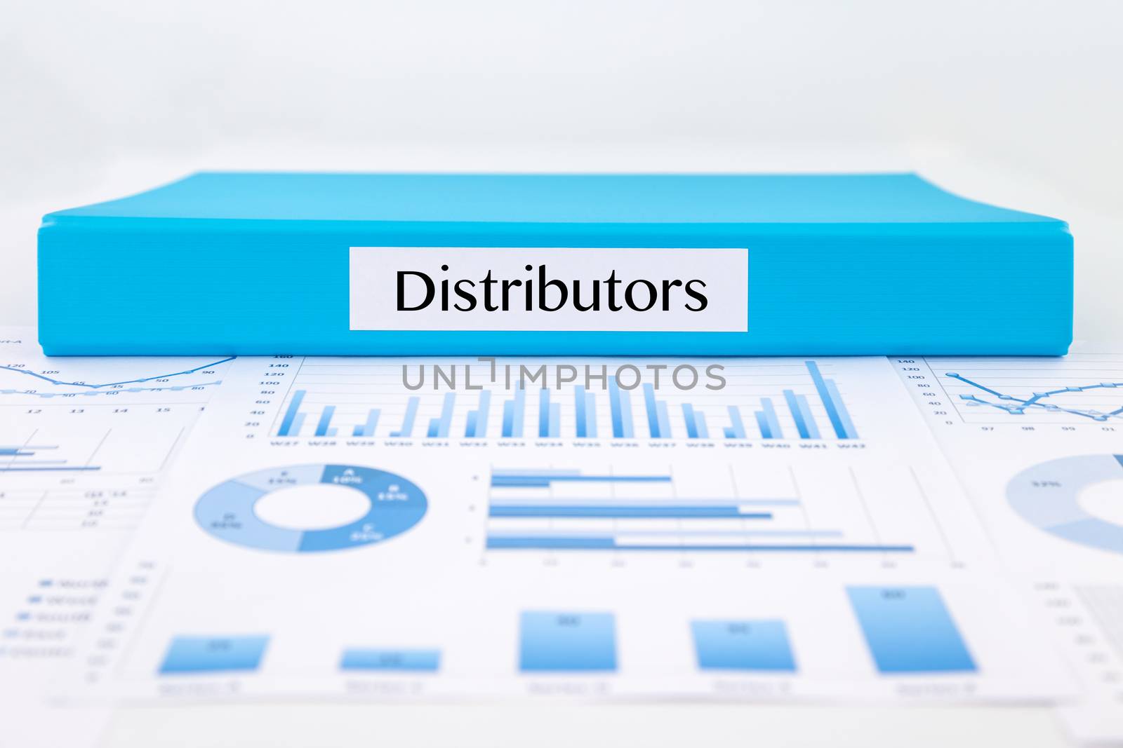 Blue document binder with Distributors word place on graphs analysis and marketing reports