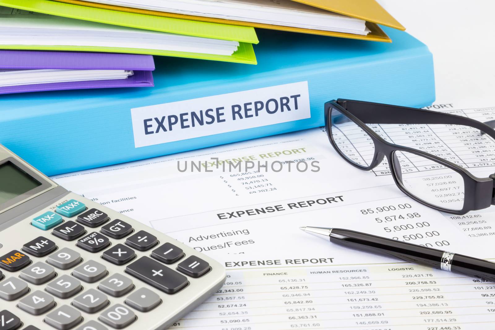 Business expense report binder with financial documents and calculator