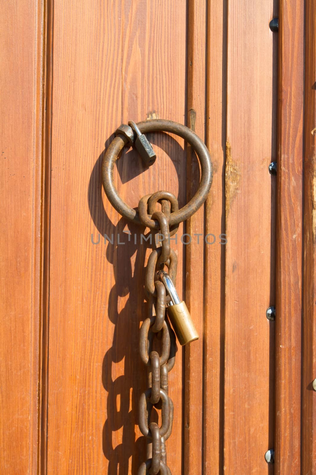 Closed wooden door with chain and lock on.