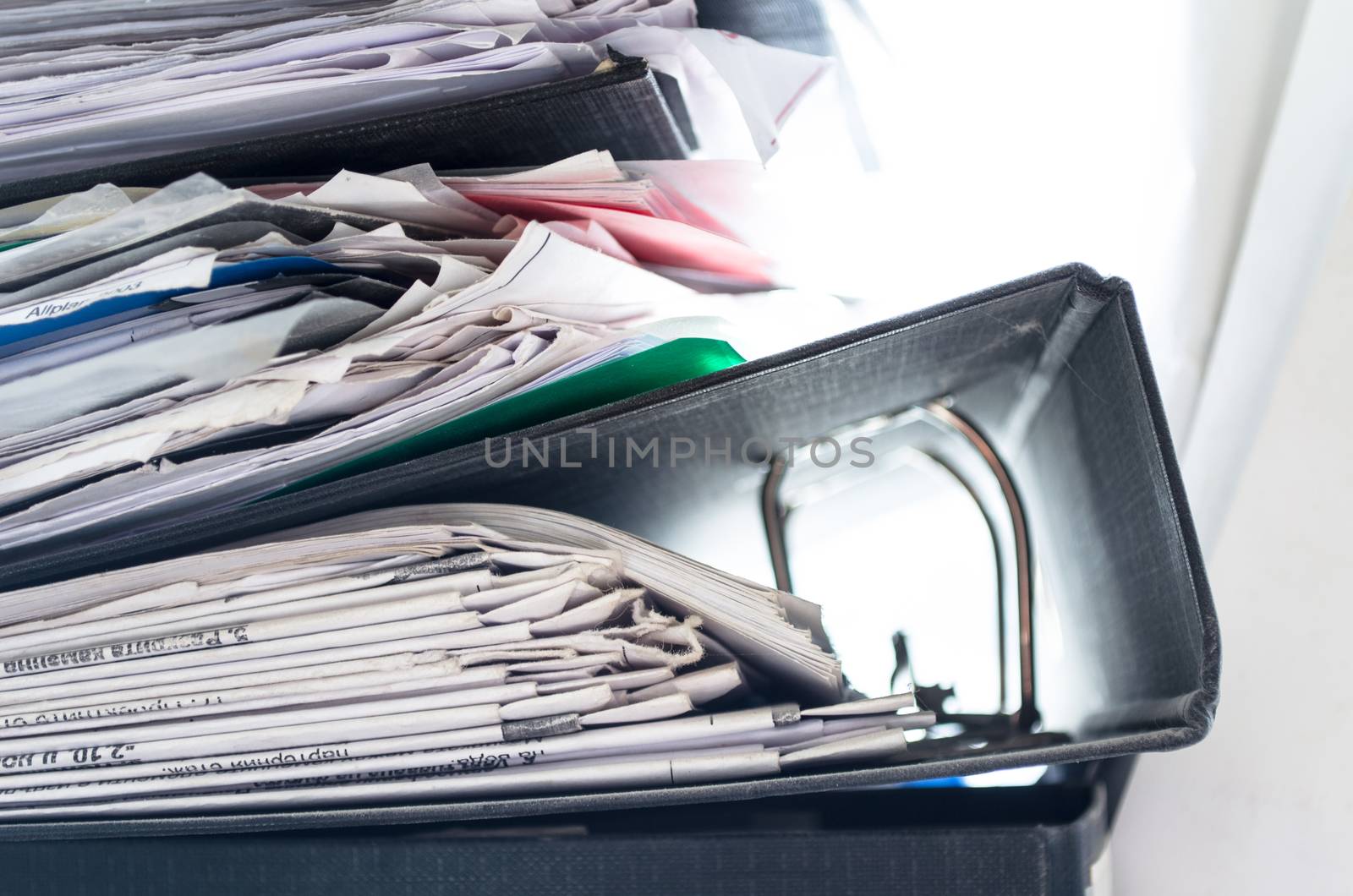 Red, green, blue and yellow office folders with boxes on the gray shelf